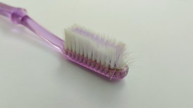 Beyaz arka planda diş fırçası vardı. Plaket ve bakteri yıpranmış bir diş fırçası ile temizlenemez ve diş etlerine de zarar verebilir..