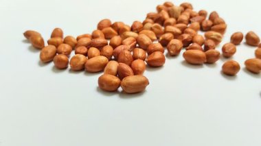 Beyaz arka planda derilerinden soyulmuş fıstıklar.