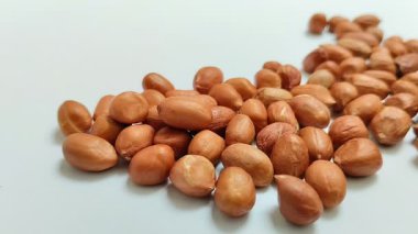 Beyaz arka planda derilerinden soyulmuş fıstıklar.