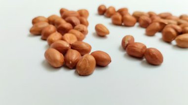 Beyaz arka planda derilerinden soyulmuş fıstıklar.