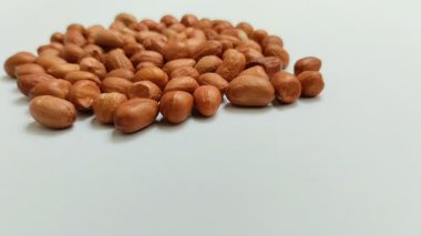 Beyaz arka planda derilerinden soyulmuş fıstıklar.