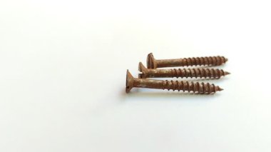 Beyaz arka planda paslı vida. Pas, demir, oksijen ve su arasındaki kimyasal etkileşimin bir sonucu olarak oluşur ve bu da metal yüzeyi aşındırır..