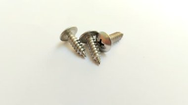 Beyaz arka planda bir çift kiriş vidası var. Bu vidalar büyük bir alan ve düşük profil gerektiren montaj panelleri, levha metal veya ahşap yapı için idealdir.