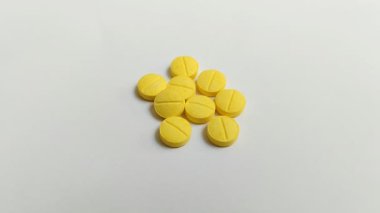 Beyaz arkaplanda küçük sarı bir tablet.