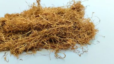 Beyaz arka planda kurumuş tütün yığını. Tütün, yaprakları sigara için hammadde olarak yaygın olarak kullanılan bir bitkidir.