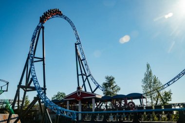 Helsinki, Finlandiya - 24 Haziran 2022: Lunaparktaki Linnanmaki gökyüzü arka planında bulanık hareket halinde hız trenine binin