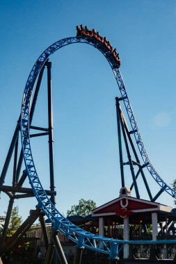 Helsinki, Finlandiya - 24 Haziran 2022: Lunaparktaki Linnanmaki gökyüzü arka planında bulanık hareket halinde hız trenine binin