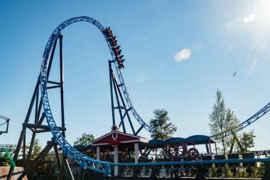 Helsinki, Finlandiya - 24 Haziran 2022: Lunaparktaki Linnanmaki gökyüzü arka planında bulanık hareket halinde hız trenine binin