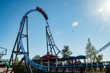 Helsinki, Finlandiya - 24 Haziran 2022: Lunaparktaki Linnanmaki gökyüzü arka planında bulanık hareket halinde hız trenine binin