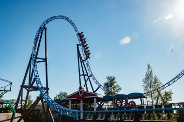 Helsinki, Finlandiya - 24 Haziran 2022: Lunaparktaki Linnanmaki gökyüzü arka planında bulanık hareket halinde hız trenine binin