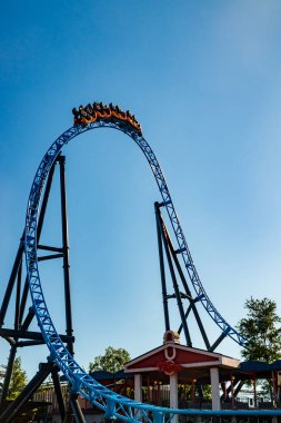 Helsinki, Finlandiya - 24 Haziran 2022: Lunaparktaki Linnanmaki gökyüzü arka planında bulanık hareket halinde hız trenine binin