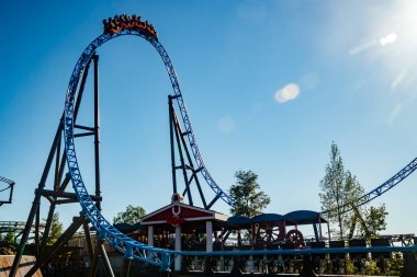 Helsinki, Finlandiya - 24 Haziran 2022: Lunaparktaki Linnanmaki gökyüzü arka planında bulanık hareket halinde hız trenine binin