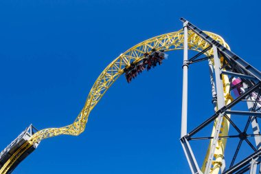 Helsinki, Finlandiya - 24 Haziran 2022: Linnanmaki lunaparkının mavi gökyüzü arkaplanındaki bulanık hareketli hız treni Ukko ile görüntüsü.