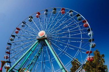 Mavi gökyüzü arka planındaki lunaparkta dönme dolap..