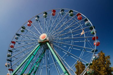Mavi gökyüzü arka planındaki lunaparkta dönme dolap..