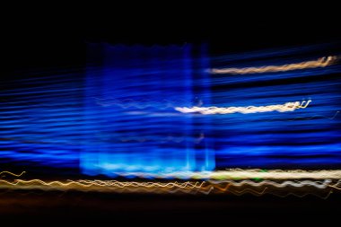 Siyah bir arka plan üzerinde bulanık renkli ışık etkisi Özet. Uzun pozlama fotoğraf hareketli kamera.