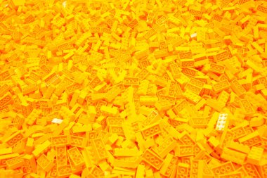 Billund, Danimarka - 17 Haziran 2023: Sarı plastik lego tuğla arka plan