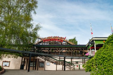 Helsinki, Finlandiya - 21 Mayıs 2023: Lunaparktaki gökyüzü arka planında hareket halindeki hız trenine binin Linnanmaki