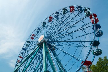 Gökyüzü arka planındaki eğlence parkında hareketli renkli dönme dolap..