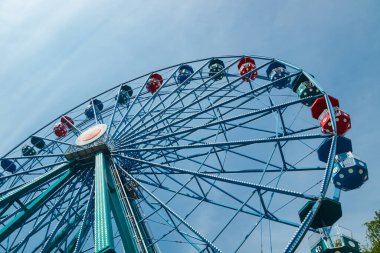 Gökyüzü arka planındaki eğlence parkında hareketli renkli dönme dolap..