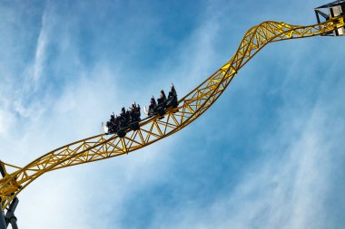 Lunaparkta hareket halindeki hız trenini mavi gökyüzü arka planında sür.