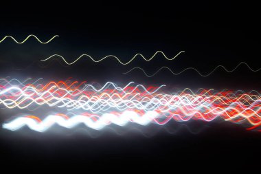 Siyah bir arka plan üzerinde bulanık renkli ışık etkisi Özet. Uzun pozlama fotoğraf hareketli kamera.