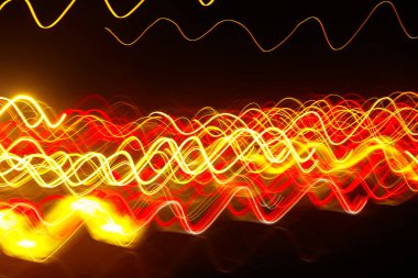 Siyah bir arka plan üzerinde bulanık renkli ışık etkisi Özet. Uzun pozlama fotoğraf hareketli kamera.