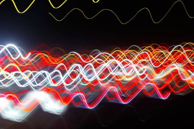 Siyah bir arka plan üzerinde bulanık renkli ışık etkisi Özet. Uzun pozlama fotoğraf hareketli kamera.