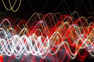 Siyah bir arka plan üzerinde bulanık renkli ışık etkisi Özet. Uzun pozlama fotoğraf hareketli kamera.