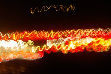 Siyah bir arka plan üzerinde bulanık renkli ışık etkisi Özet. Uzun pozlama fotoğraf hareketli kamera.