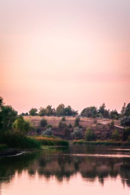 Arkasında ağaç olan güzel bir nehir manzarası.