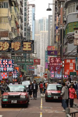 Hong Kong, Çin - 5 Şubat 2019: Hong Kong 'da taksilerin, neon ışıkların ve insanların iş hayatına devam ettiği yoğun bir sokak manzarası.