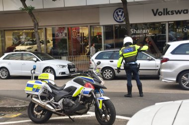 Hong Kong, Çin - 12 Aralık 2019: Bir motosiklet polisi yoğun bir Hong Kong caddesinde trafiği yönetiyor.