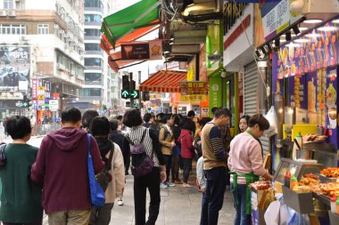 Hong Kong, Çin - 5 Şubat 2019: İnsanlar kalabalık bir Hong Kong caddesinde Ay Yeni Yılı boyunca sokak yiyecek satıcılarının önünden geçtiler.