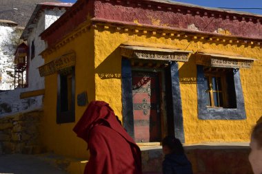 Lhasa, Tibet, Çin - 21 Ocak 2020: Geleneksel kırmızı cüppeli bir keşiş Lhasa yakınlarındaki Drepung Manastırı 'ndan geçiyor.