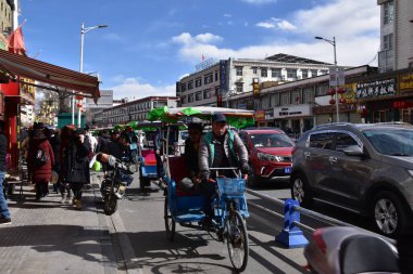 Lhasa, Tibet, Çin - 22 Ocak 2020: Bir tuk-tuk Lhasa, Tibet Özerk Bölgesi 'nde işlek bir caddede ilerliyor.