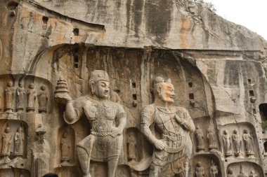 Buddhist statues carved into the cliffs at Longmen Grottoes in Luoyang clipart