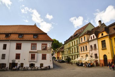 Sighisoara 'nın kaldırımlı kasaba meydanı ve renkli binaları