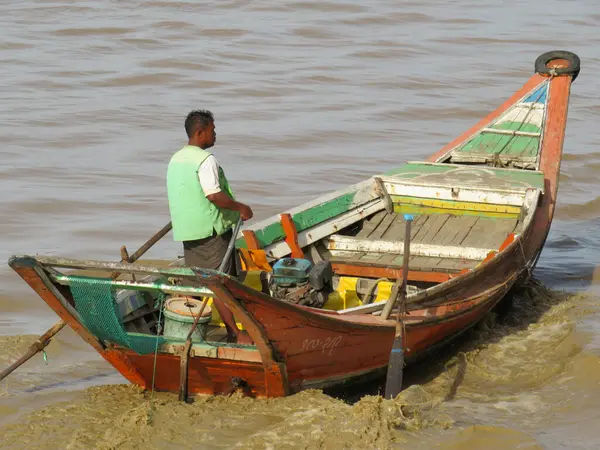 13 Mayıs 2025 - Yangon, Myanmar: Myanmar 'daki Yangon Nehri' nin çamurlu sularında ahşap balıkçı teknesi