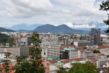 Ljublana 'nın ufuk çizgisi ve bulutlu gökyüzünün altındaki dağlar