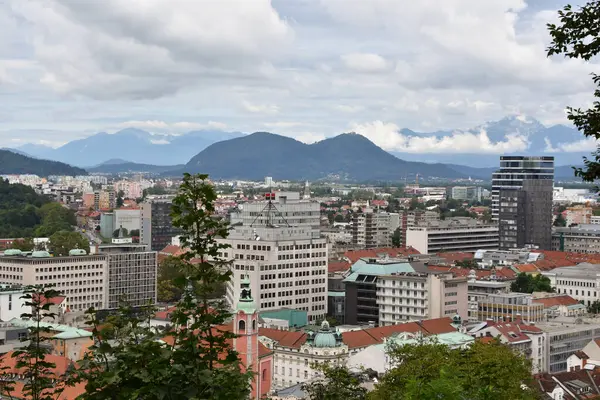 Ljublana 'nın ufuk çizgisi ve bulutlu gökyüzünün altındaki dağlar