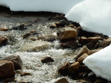 Güneş, kışın Kazakistan 'da karla kaplı bir dereden yansıyor.