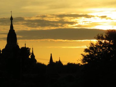 Myanmar 'daki Bagan tapınağının üzerinde sarı gün doğumu