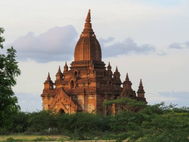 Myanmar, Bagan 'da akşam güneşinde yıkanan kırmızı bir tapınak.
