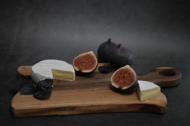 Köy tahtasına dizilmiş lezzetli bir peynir ve incir tabağı.