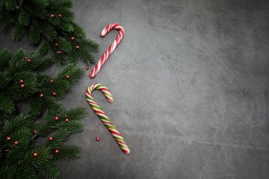 Kutlama şeker kamışları ve arka planda süslemeleri olan Noel ağacı dalları, üst manzara. Noel.