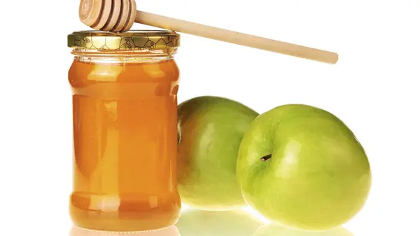 stock image A symbolic image for Rosh Hashanah featuring apples and honey, representing sweetness and blessings for the Jewish New Year. Ideal for cultural and holiday-themed projects.