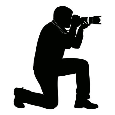 Profesyonel bir fotoğrafçının silueti diz çöküp kamerayla bir anı yakalıyor.