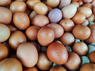 A close-up image of numerous fresh brown eggs. The eggs vary slightly in size and shade, representing farm-fresh organic produce. Ideal for food, farming, and organic product clipart