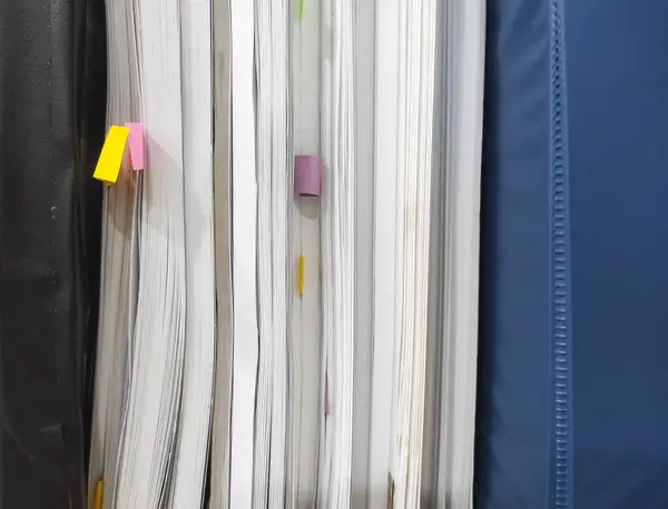 stock image several stacked books with colorful sticky notes marking various pages